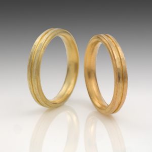 Two 18 carat gold rings with hammered stripes in yellow and rose gold Two 18 carat gold rings with hammered stripes in yellow and rose gold