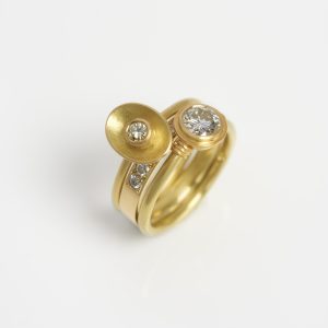 18 carat gold three ring stack - a large solitaire diamond ring with 22 carat gold details; a yellow diamond in an oval setting and a pavé-set half eternity ring 18 carat gold three ring stack - a large solitaire diamond ring with 22 carat gold details; a yellow diamond in an oval setting and a pavé-set half eternity ring
