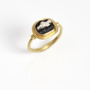 18 carat gold ring with 22 carat gold setting with an ancient oval cameo of clasped hands and ‘friendship’ in Greek lettering 18 carat gold ring with 22 carat gold setting with an ancient oval cameo of clasped hands and ‘friendship’ in Greek lettering
