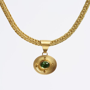 22 carat gold pendant with four granules, set with an oval cabochon tzavorite 22 carat gold pendant with four granules, set with an oval cabochon tzavorite