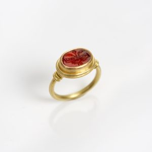 18 carat gold ring with antique cornelian Roman intaglio set in 22 carat gold with twists on shoulders 18 carat gold ring with antique cornelian Roman intaglio set in 22 carat gold with twists on shoulders