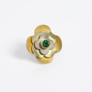 Lapel pin in silver, 24 carat gold, 18 carat green gold; white gold and yellow gold with facetted tzavorite